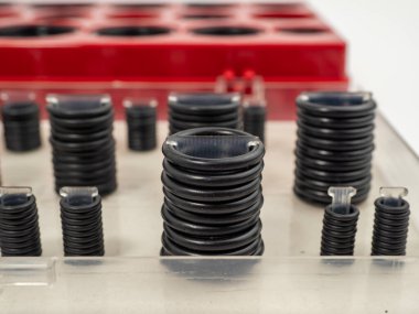 Hydraulic and pneumatic o-rings in black in different sizes on a white background. Rubber gaskets for plumbing. copy space.