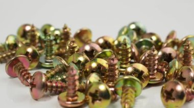 Metal screws on a white background. Rotating screws for driving into plastic. Close-up.