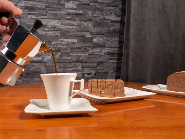 A piece of chocolate cake and a cup of coffee on a wooden table. Dessert.