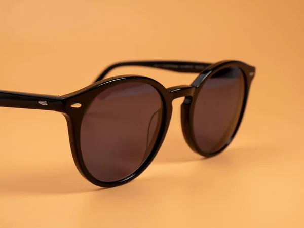 Stylowe Okulary Przeciwsłoneczne Okulary Przeciwsłoneczne Ciemnej Ramce Pomarańczowym Tle Zbliżenie — Zdjęcie stockowe