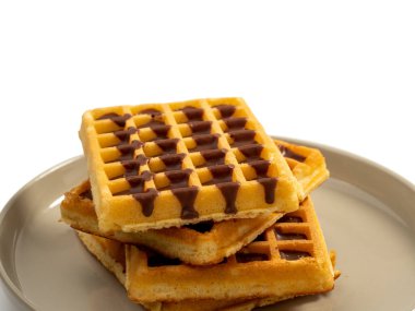 Beyaz arka planda izole edilmiş bir tabakta çikolatalı waffle. Çikolatalı waffle. Yakın plan..