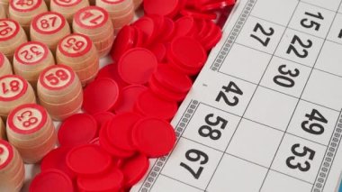Bingo tahtası oyunu. Tahta varillerde numaralar, tombala fişleri ve kartlar dönüyor. Yakın plan..