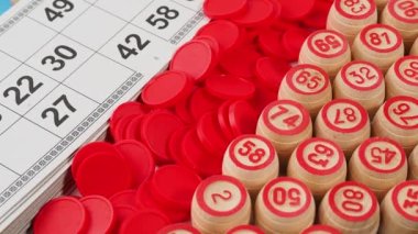 Bingo tahtası oyunu. Tahta varillerde numaralar, tombala fişleri ve kartlar dönüyor. Yakın plan..