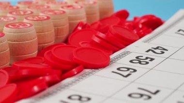 Bingo tahtası oyunu. Tahta varillerde numaralar, tombala fişleri ve kartlar dönüyor. Yakın plan..