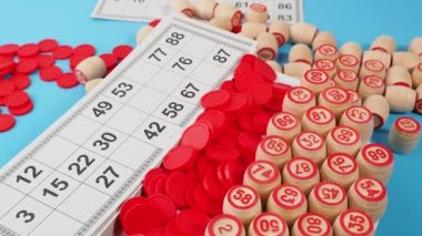 Bingo tahtası oyunu. Tahta varillerde numaralar, tombala fişleri ve kartlar dönüyor. Yakın plan..