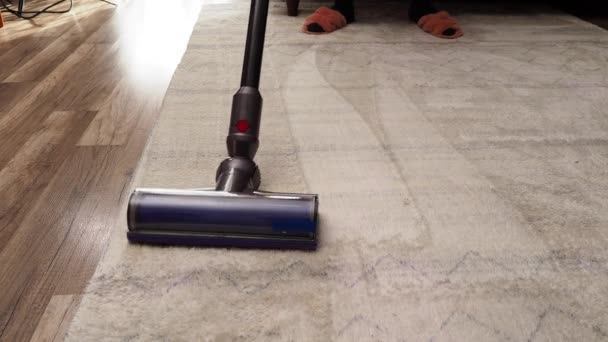 一个女人用现代真空吸尘器吸尘地毯 清扫房屋 — 图库视频影像