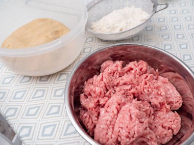 Mutfak masasındaki metal kasede kıyma. Yakın plan..