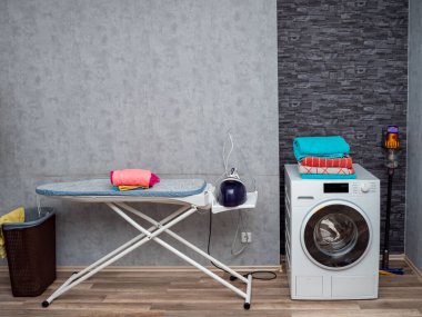 Çamaşır odasının içinde duvarda çamaşır makinesi var. Modern çamaşır makinesi.