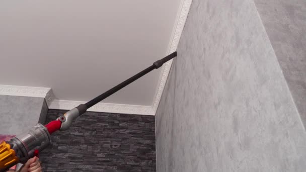 女性は現代の掃除機で天井からほこりを除去します 家の掃除 — ストック動画