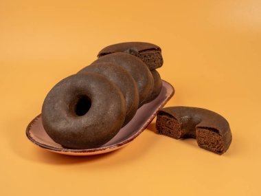 Turuncu arka planda bir tabakta taze vejetaryen çöreği. Yakın plan..