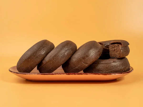 Φρέσκο Σκούρο Χορτοφαγικό Ντόνατ Πιάτο Πορτοκαλί Φόντο Κοντινό Πλάνο — Φωτογραφία Αρχείου
