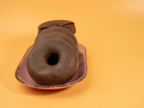 Frischer Dunkler Vegetarischer Donut Auf Einem Teller Auf Orangefarbenem Hintergrund — Stockfoto