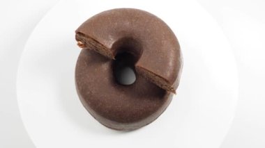 Dönüşümlü koyu vejetaryen çöreği beyaz arka planda izole edilmiş. Donut yakın çekim.