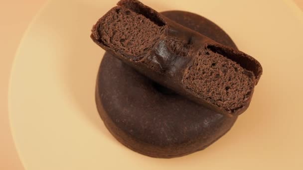 Donut Vegetariano Escuro Rotativo Fundo Laranja Donut Close — Vídeo de Stock