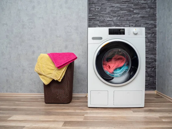 Çamaşır odasının içinde duvarda çamaşır makinesi var. Modern çamaşır makinesi.