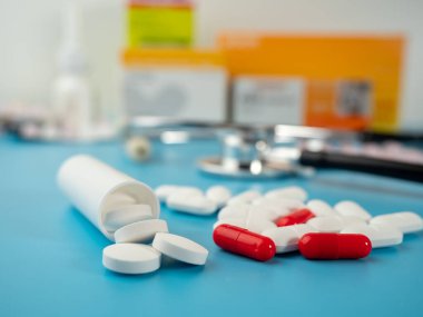 Mavi arka planda ilaçlar. Kapsüller, tabletler ve ampuller. Yakın plan..