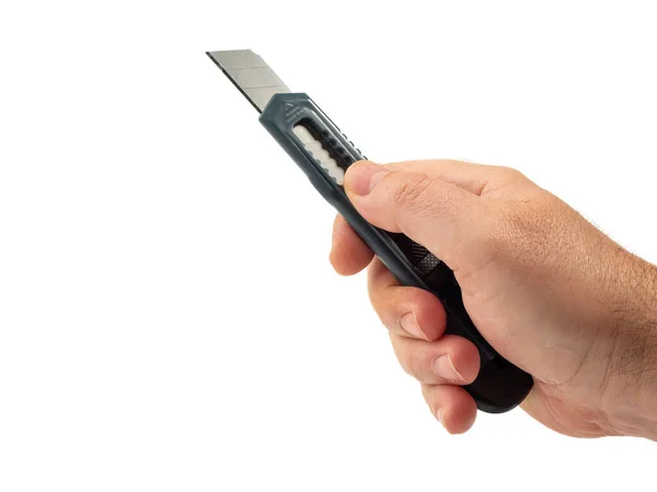 stock image Holds a box cutter in his hand on a white background. close-up.