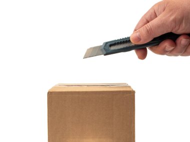 Karton kutu bir bıçakla açılır. Beyaz arkaplan.