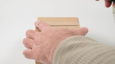 Karton kutu bir bıçakla açılır. Beyaz arkaplan.