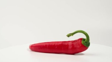 Kırmızı biberler beyaz arka planda döner. baharat.