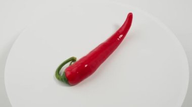 Kırmızı biberler beyaz arka planda döner. baharat.