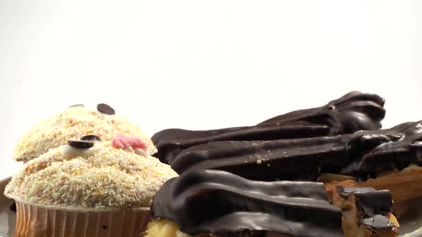 Rotierender Schokoladenkuchen Muffin Und Eclairs Leckere Süßigkeiten Nahaufnahme — Stockvideo