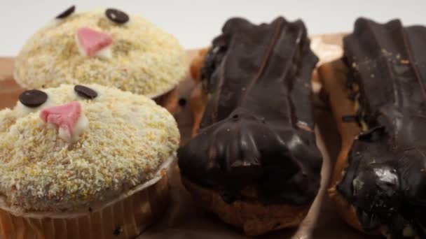 チョコレートケーキ マフィンとエクレアを回転させます おいしいお菓子 — ストック動画