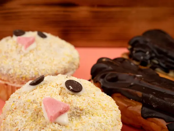 Muffins Och Choklad Eklair Isolerad Rosa Bakgrund Läckra Sötsaker Närbild — Stockfoto