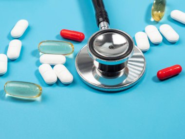 Mavi arka planda haplar ve steteskop. Tıp konsepti. Yakın plan..