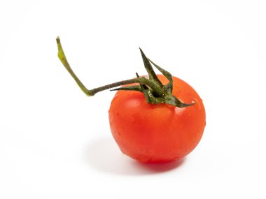 Beyaz arka planda izole edilmiş yeşil saplı bir avuç taze kırmızı domates. Domatesler yakın plan..