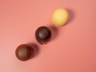 Pembe arka planda çikolata kaplı marşmelov. Yakın plan.