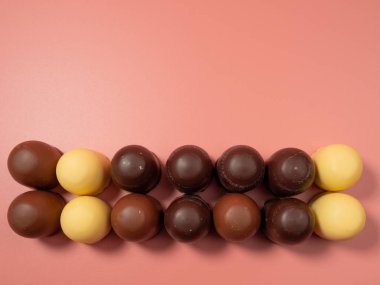 Pembe arka planda çikolata kaplı marşmelov. Yakın plan.