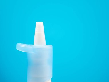 Burun spreyi şişeleri mavi arka planda, soğuk algınlığını burun spreyiyle tedavi ediyor. Tıbbı yakın çekim.