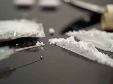 Siyah arka planda iğne ve kokain tozu için şırınga. Uyuşturucu ve para..