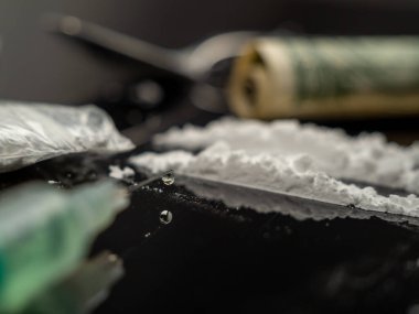 Siyah arka planda iğne ve kokain tozu için şırınga. Uyuşturucu ve para..