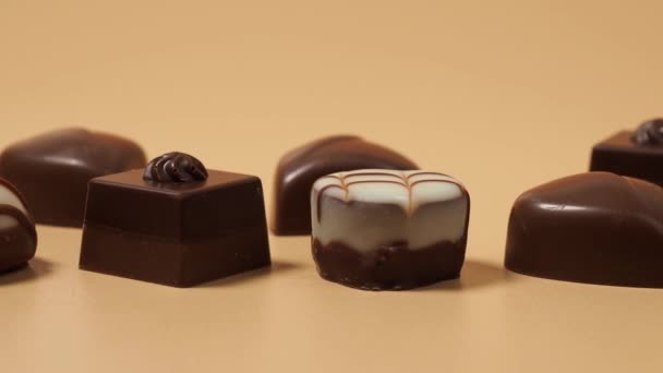 Verschiedene Gourmet Pralinen Weißer Dunkler Und Milchschokolade Schokoladenbonbons Auf Orangefarbenem — Stockvideo