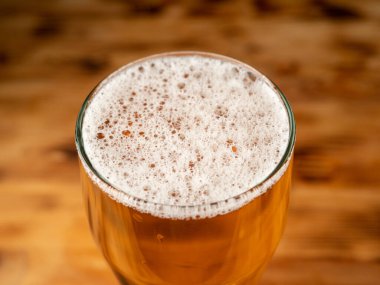 Karanlık bir arka planda bir bardak soğuk bira. Bir bardak yakın plan bira..