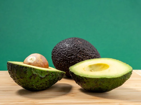 Avocado on a green background. Ripe avocado.