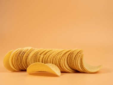 Turuncu arka planda lezzetli patates cipsi. Patates cipsi yakın..