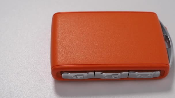 Moderner Drahtloser Orangefarbener Autozündschlüssel Auf Weißem Hintergrund Funkschlüssel Zum Starten — Stockvideo