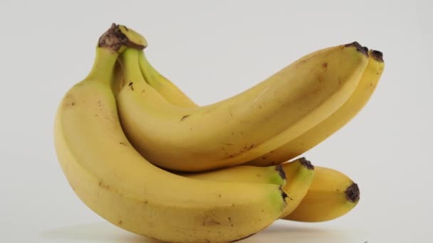 熟したバナナは白い背景で回転する バナナを閉じます — ストック動画