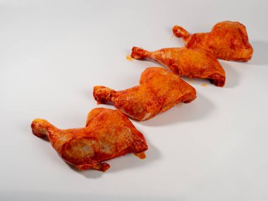 Terbiye edilmiş tavuk budu ya da bacakları beyaz bir tabakta. Terbiye edilmiş tavuk budu yakın plan..