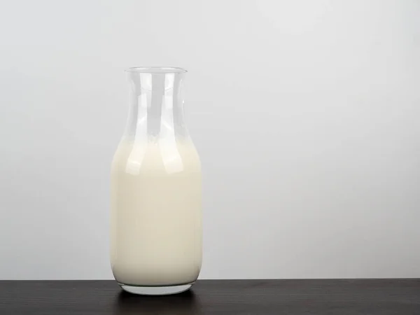 木製のテーブルの上に牛乳のボトル 軽めの背景にミルクのボトル — ストック写真