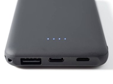 Mobil cihazları beyaz arka planda şarj etmek için güç bankası. Güç kaynağı olan akıllı telefon şarjı. Mobil aygıtlar için dış pil.