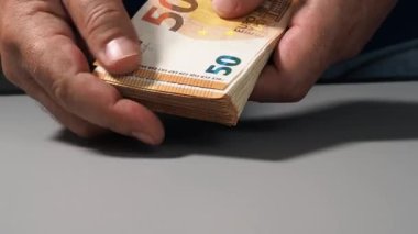 Ellerinde 50 avroluk banknotlar yığını, tasarruf bankaları, bankacılık, vergi ödeme ve para dolaşımı kavramı. AB parası.