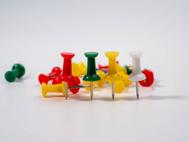 Beyaz arka planda çok renkli raptiyeler. İğneleri yaklaştır..