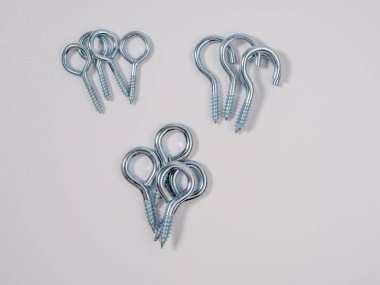 Beyaz arka planda kancası olan vidalar. Yakın çekim seti.