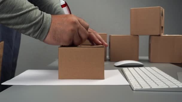 仓库里的包装商通过网上商店向买方送去了一份礼物 电子商务 货物交付 货物棕色箱 — 图库视频影像