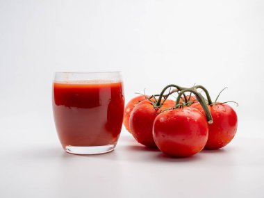 Beyaz arka planda bir bardak domates suyu. Yeni hazırlanmış domates suyu..