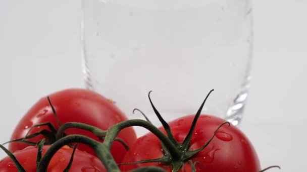 トマトジュースをグラスに注ぐ 白い背景にトマトジュースとトマトを作りました カメラズーム — ストック動画